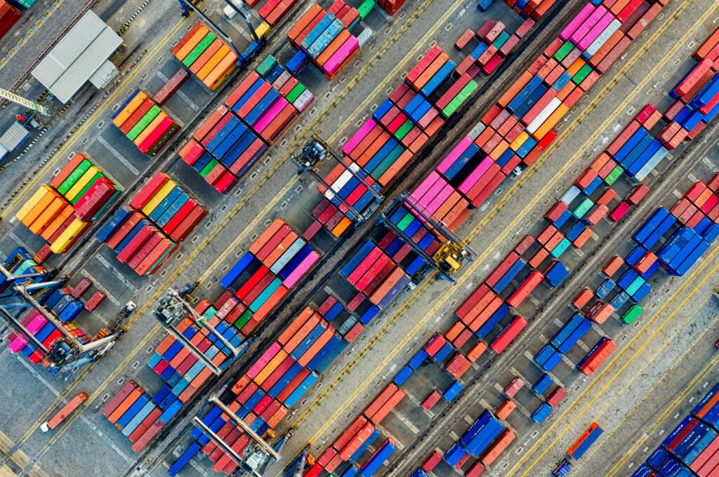 pexels-photo-3063470-3063470 Aerial view of vibrant shipping containers at a busy Jakarta port, showcasing global trade.